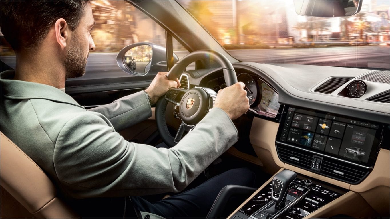 Mies ajaa Porsche Cayennea.