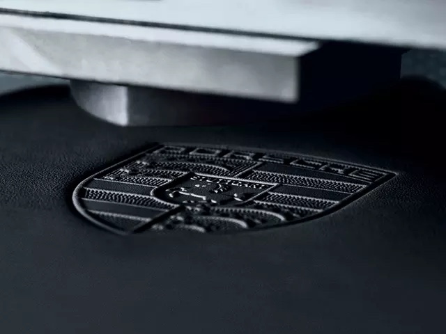 Porsche crest painettuna mustaan nahkaan.