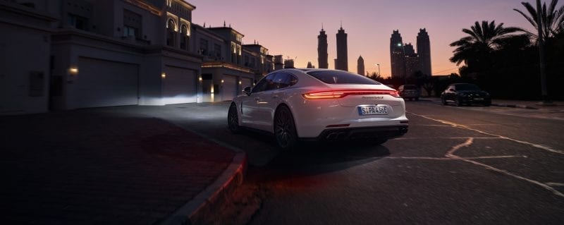 Porsche Panamera auringonlaskun aikaan kaupunkiympäristössä.