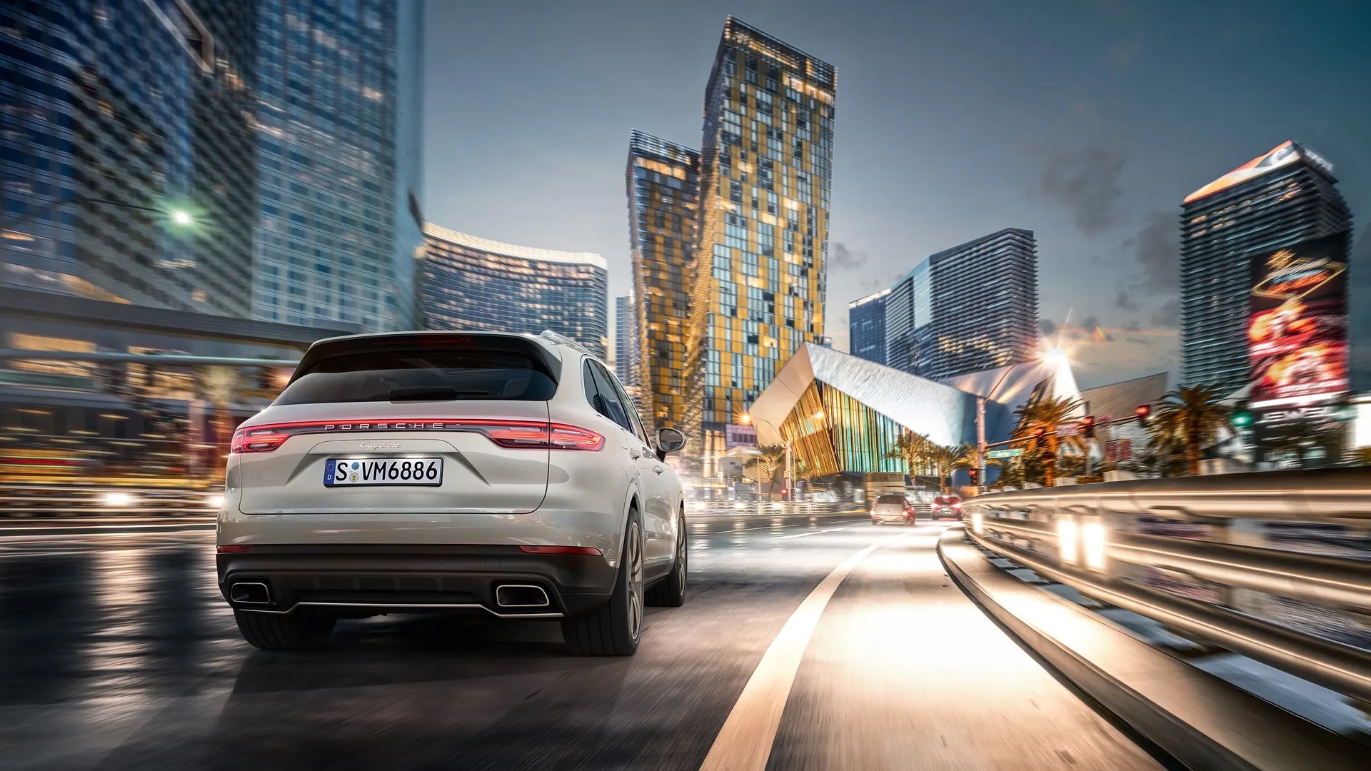Porsche Cayenne kaupungissa valojen ympäröimänä.