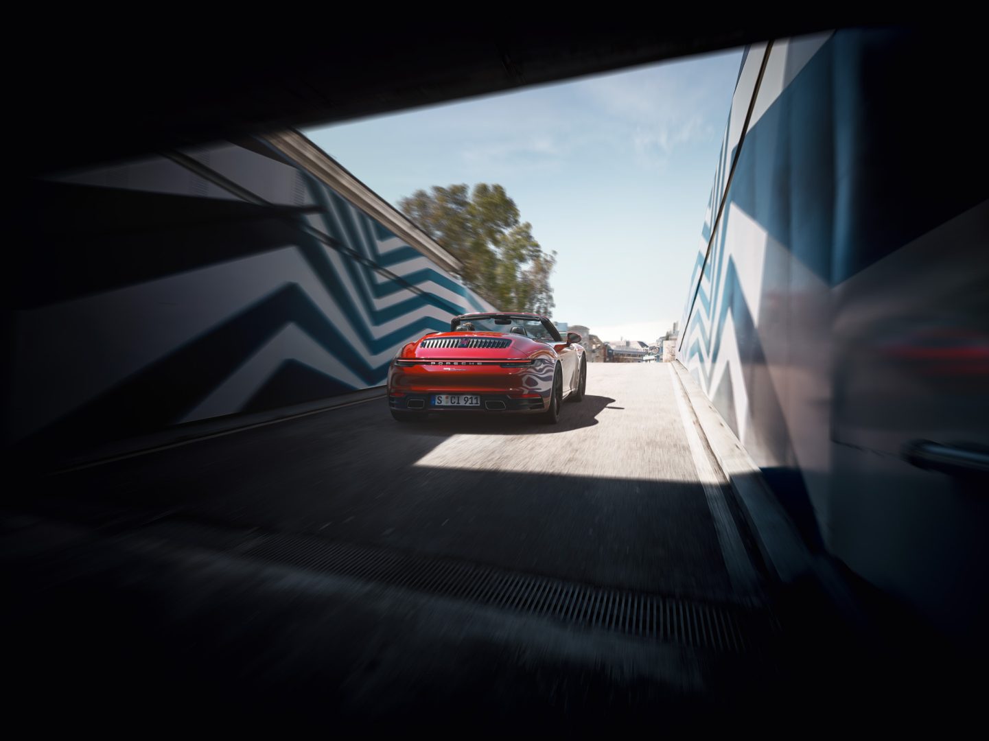 Punainen Porsche 911 ajamassa ulos tunnelista.