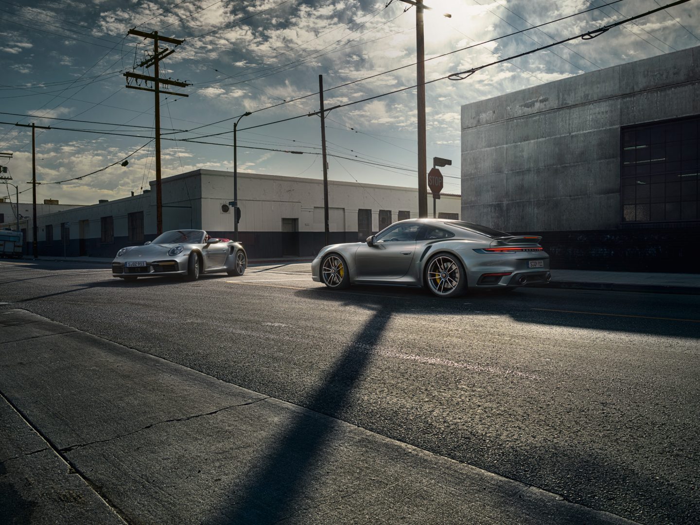 Kaksi harmaata Porsche 911 Turboa, toisenen on katto auki ja toisella on kova katto asennettuna.