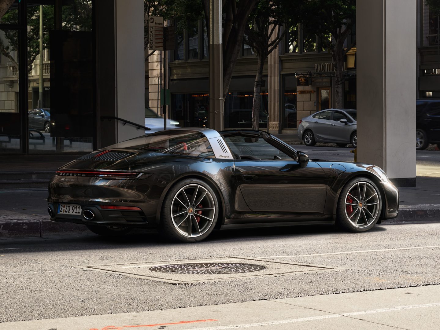 Musta Porsche 911 Targa 19″/20″ Carrera-vanteilla pysäköitynä kadunvarrelle.