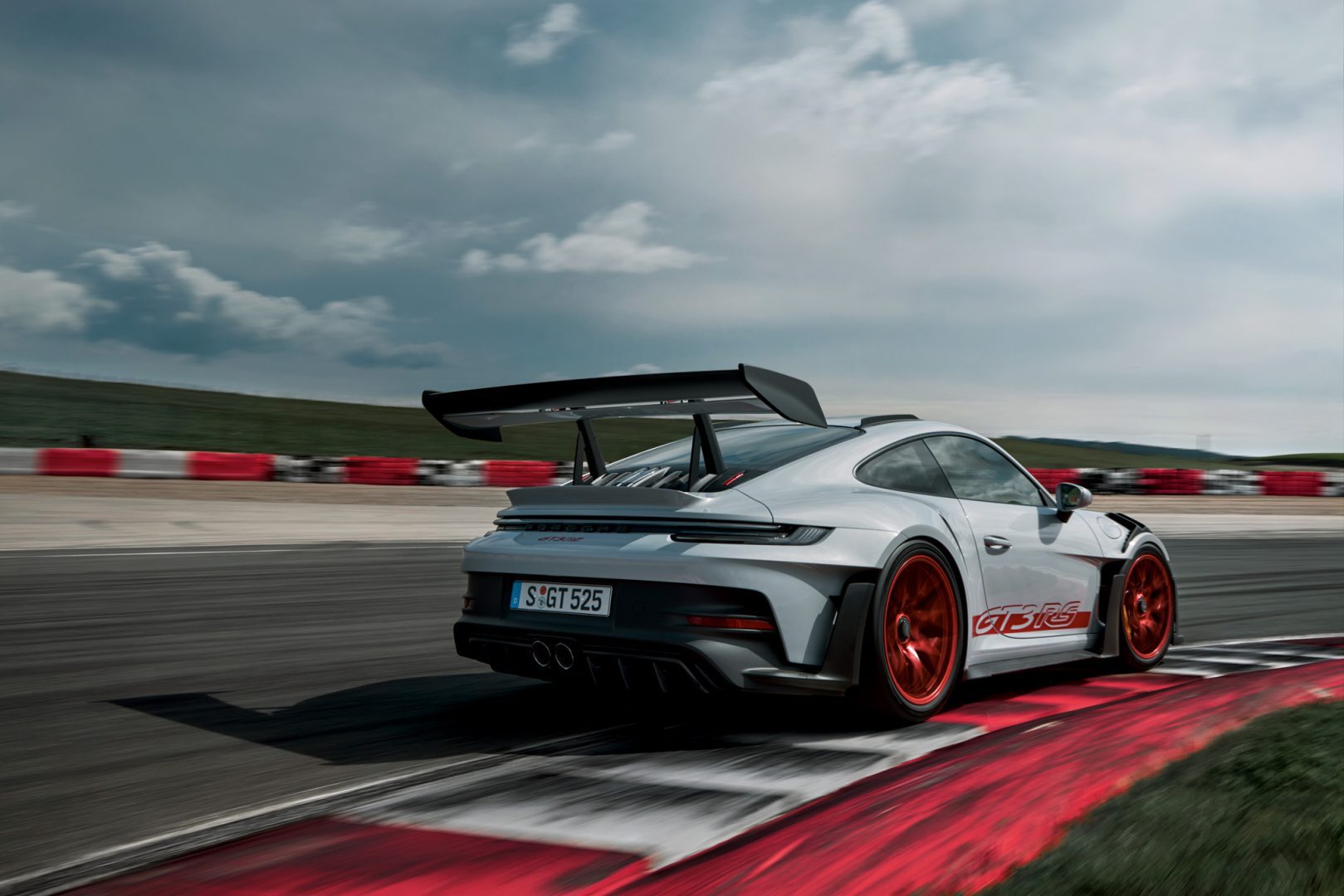 Harmaa Porsche 911 GT3 RS takaspoilerilla ajamassa kilparadalla.