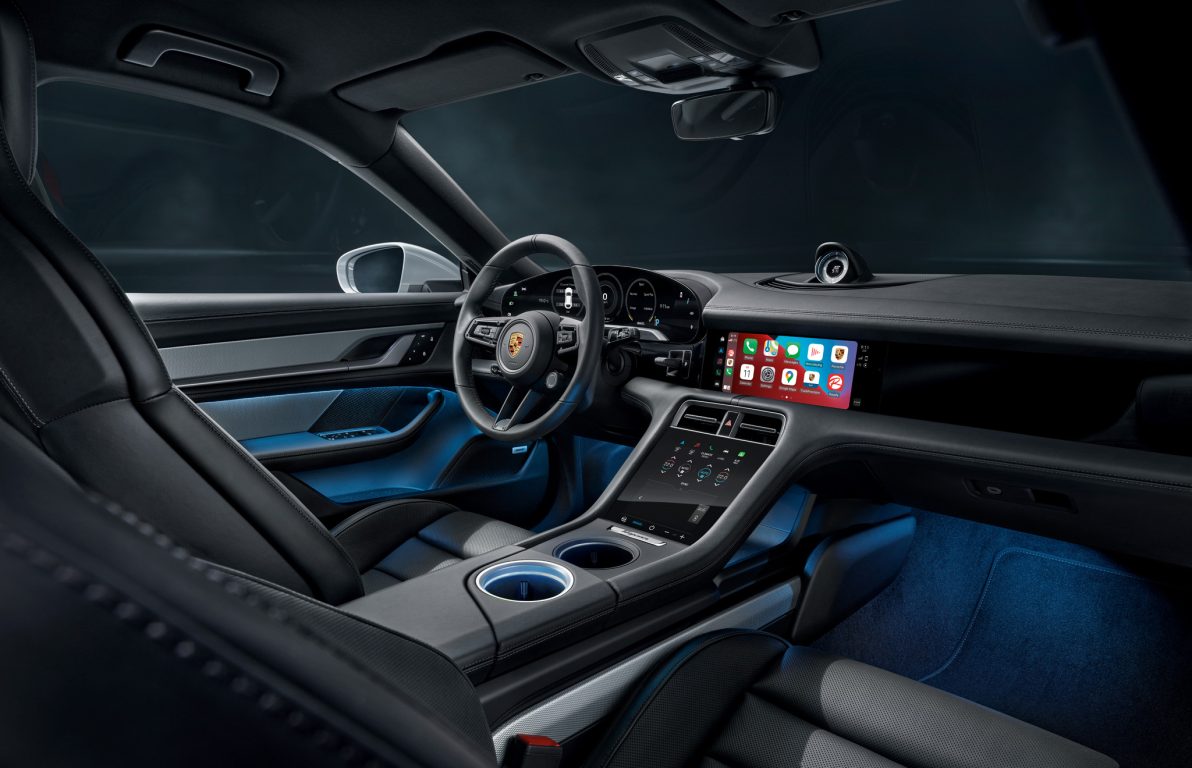 Porsche Taycan sinisellä sisätilan tunnelmavalaistuksella, sekä Apple Car play infotaimentissa.
