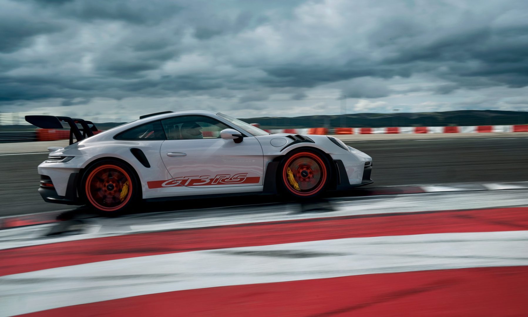 Valko-punainen Porsche 911 GT3 RS rata-olosuhteissa.