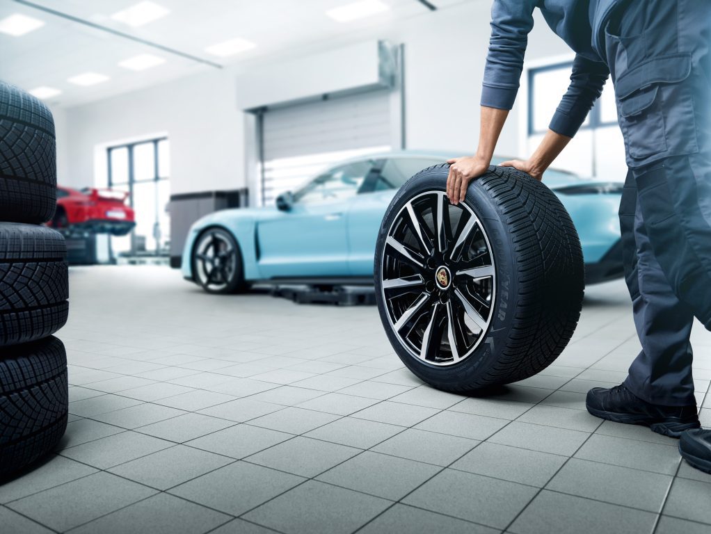 Sininen Porsche taycan renkaiden vaihdossa