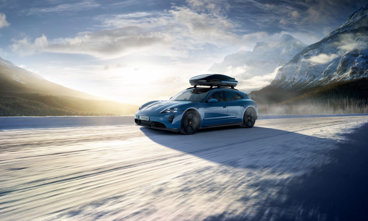 Sininen Porsche Taycan Sport Tursimo lumisissa maisemissa.