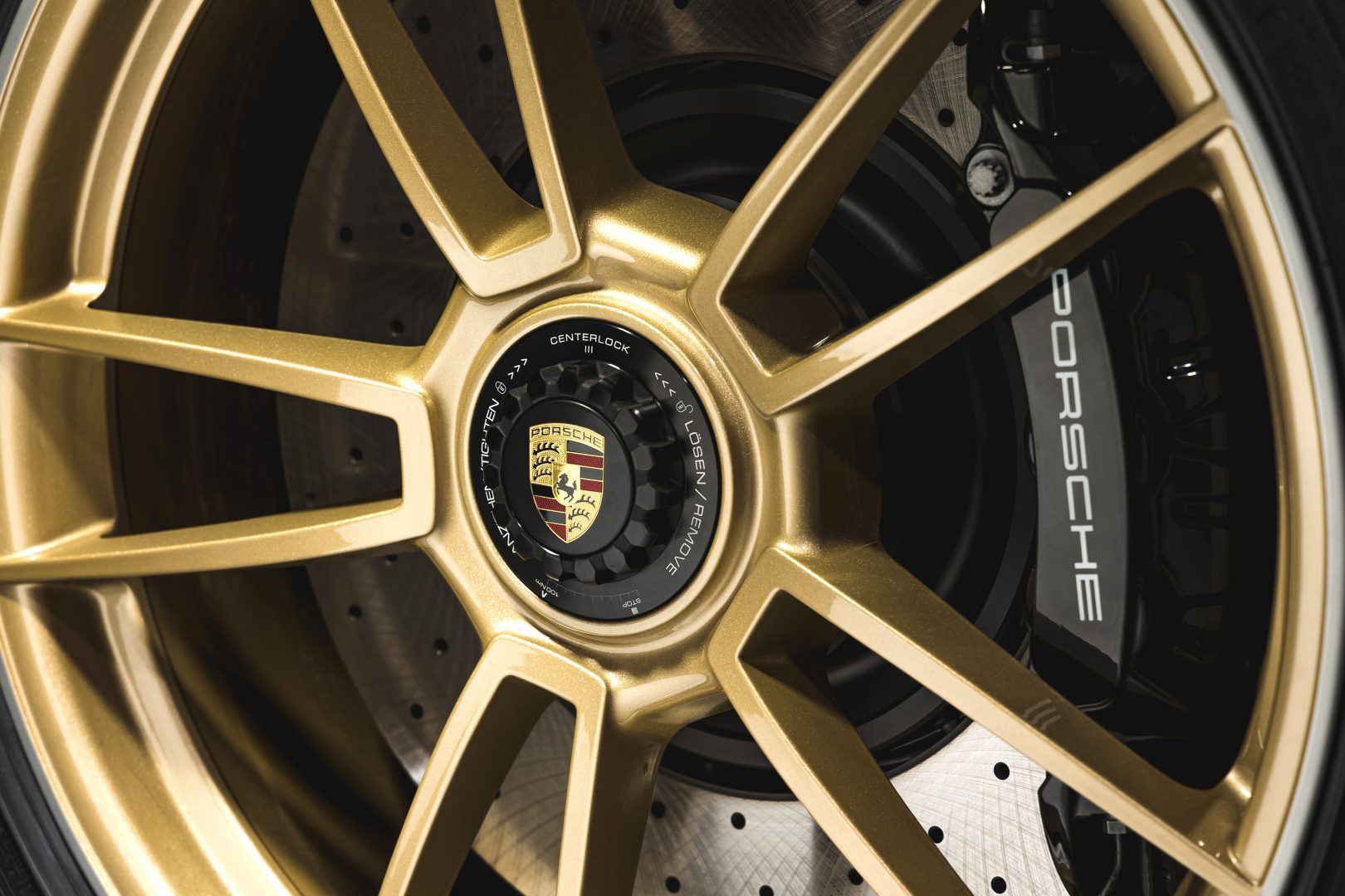 Kultaiset Porsche vanteet ja logo keskiössä.