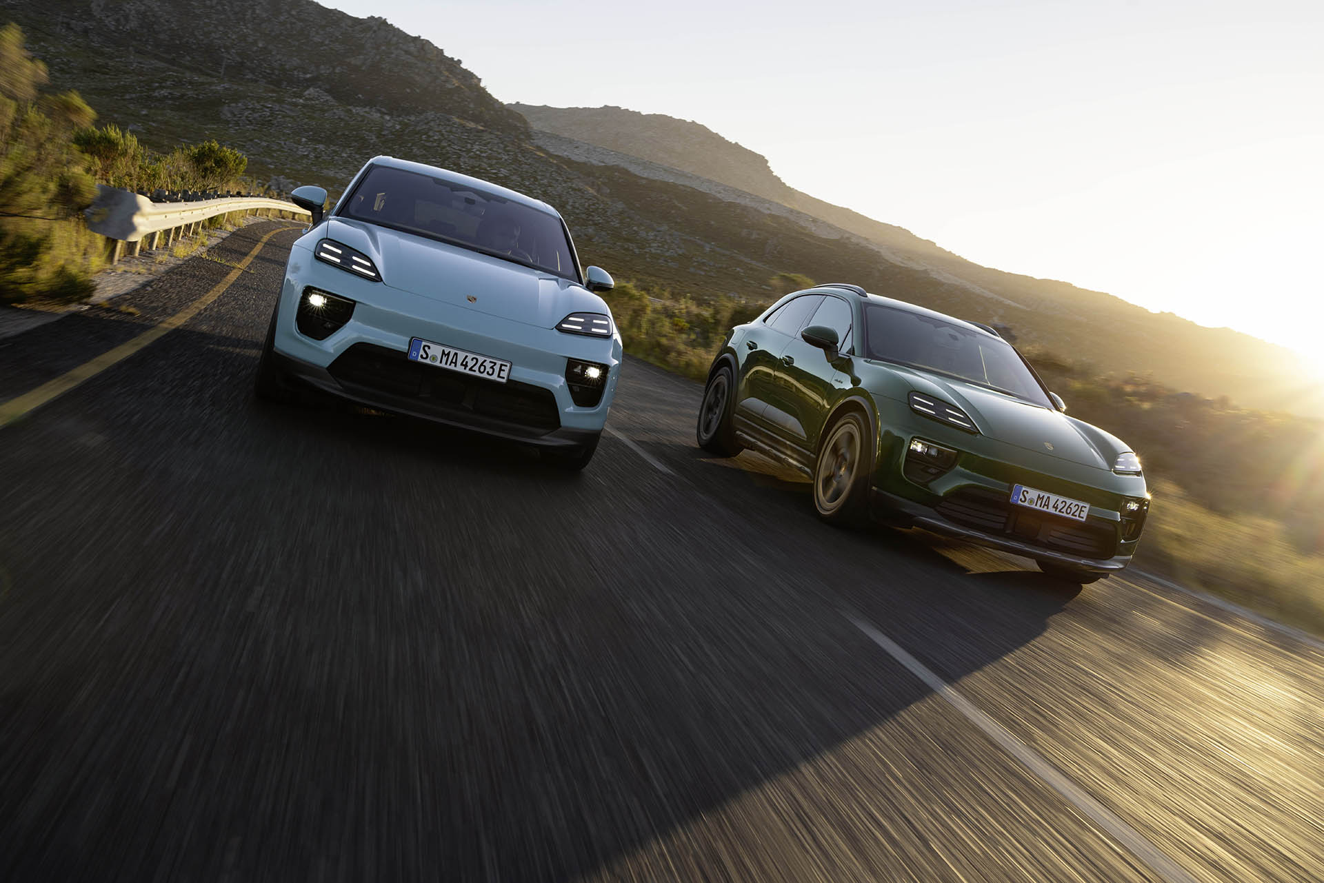 Porsche Macan 4 ja Porsche Macan Turbo rinnakkain maisemassa maantiellä