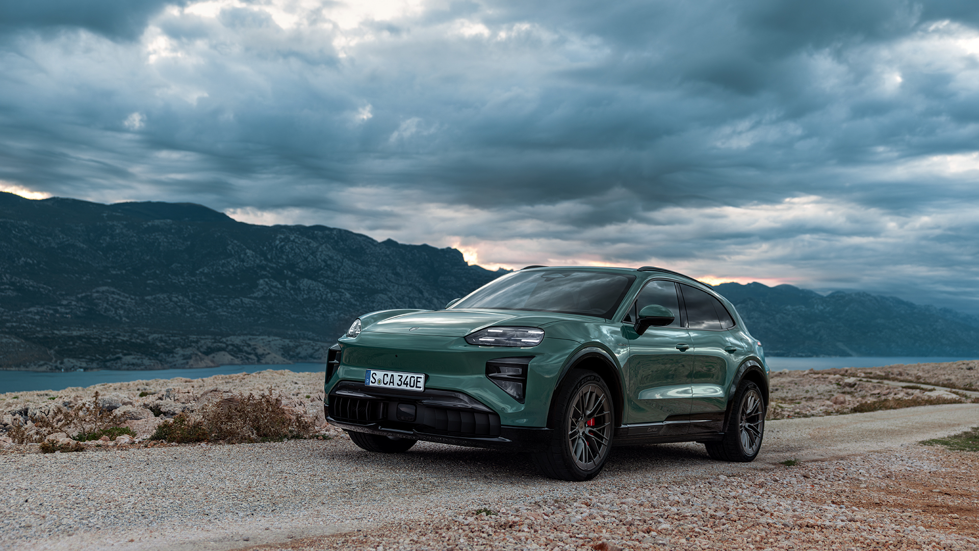 Täyssähköinen Porsche Cayenne ajossa hiekkatiellä.