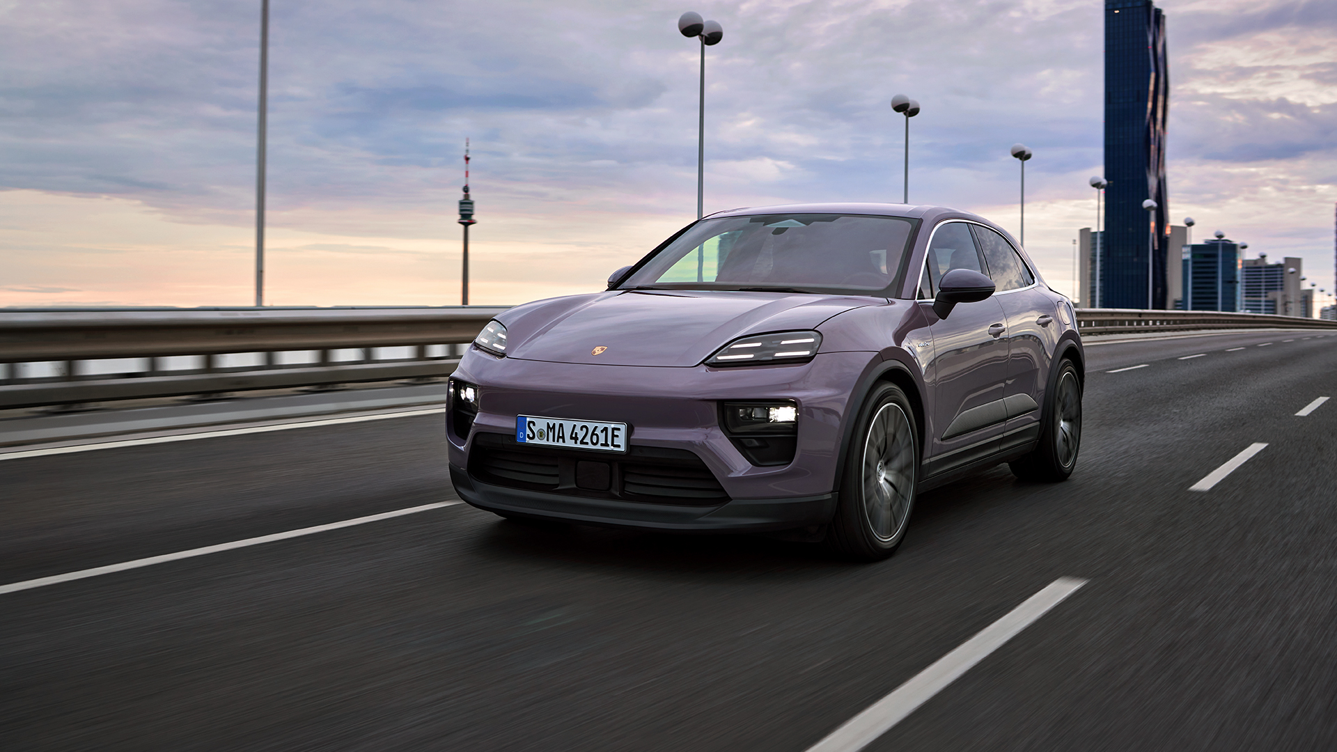Vaalean liila Porsche Macan maantiellä.